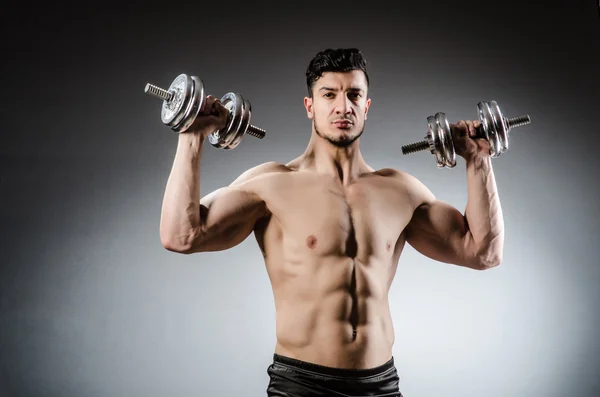 Muscular fisiculturista rasgado com halteres — Fotografia de Stock