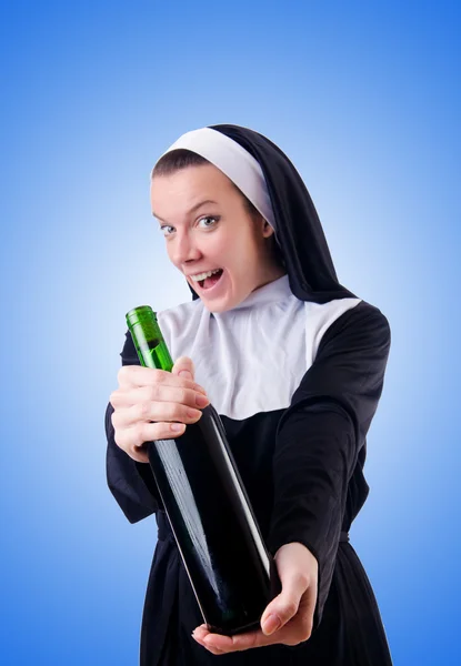 Nonne mit Flasche Rotwein — Stockfoto