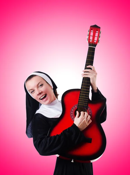 Freira tocando guitarra contra o gradiente — Fotografia de Stock