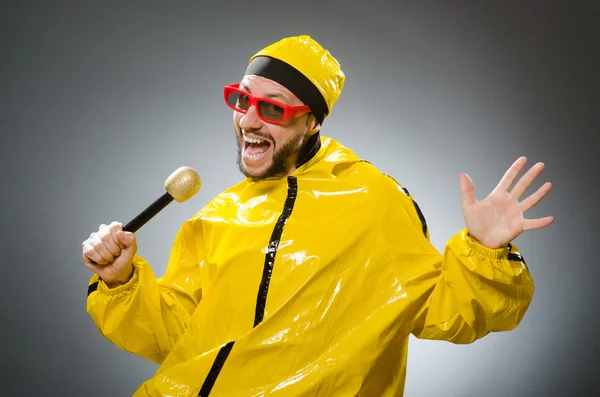 Hombre vestido de traje amarillo con micrófono — Foto de Stock