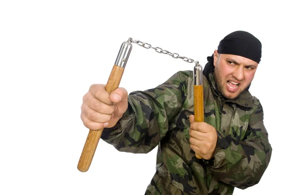 Jovem em uniforme de soldado segurando nunchaks isolado em branco — Fotografia de Stock