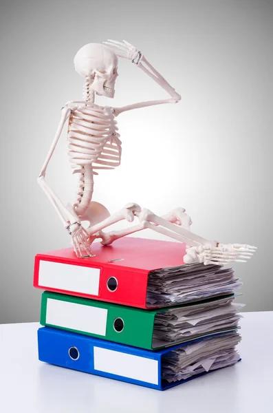 Skeleton with pile of files against gradient — Stock Photo, Image