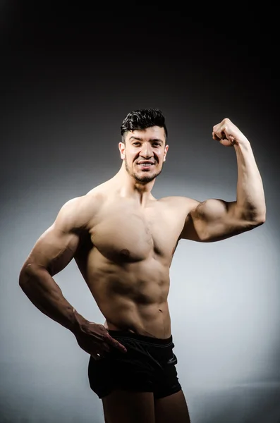 Hombre musculoso posando en estudio oscuro —  Fotos de Stock