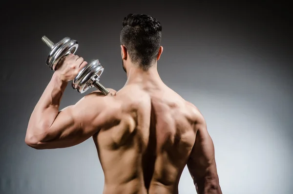 Muscular fisiculturista rasgado com halteres — Fotografia de Stock