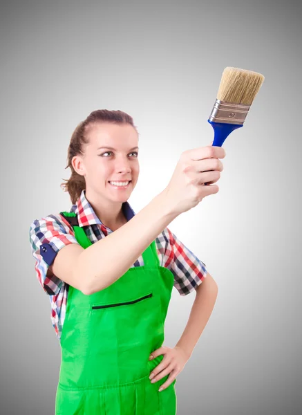 Woman painter with paintbrush against gradient — Stock Photo, Image