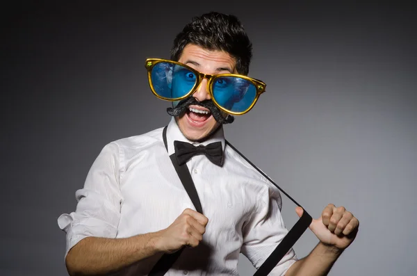 Jeune homme avec une fausse moustache et de grandes lunettes de soleil isolées sur gris — Photo