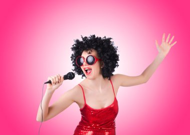 Degrade karşı Kırmızı elbiseli mikrofon ile pop yıldızı 