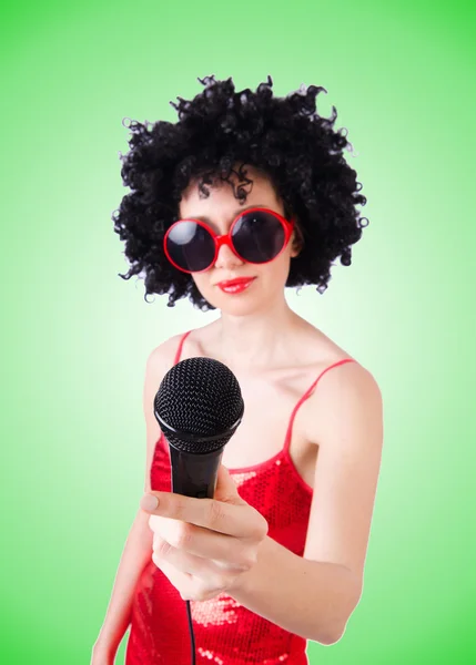 Estrella pop con micrófono en vestido rojo contra gradiente — Foto de Stock