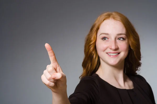 Pretty red hair girl in brown dress against gray background — Stock Photo, Image