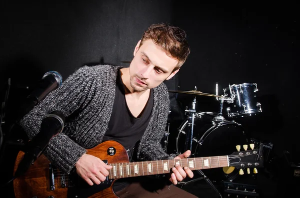 Mann spielt Gitarre im dunklen Raum — Stockfoto