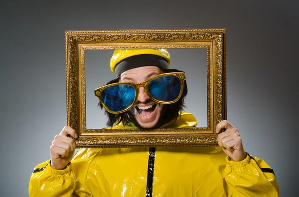 Man met gele pak met fotolijst — Stockfoto