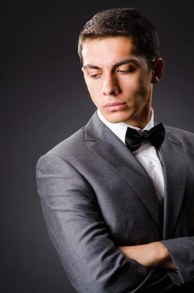 Joven hombre elegante contra gris — Foto de Stock