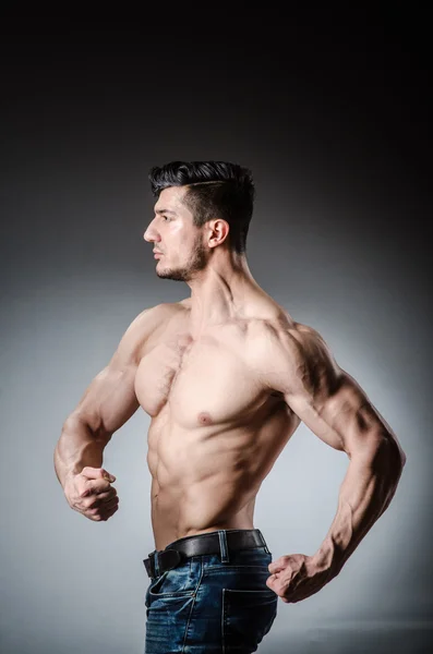 Homem muscular posando em estúdio escuro — Fotografia de Stock