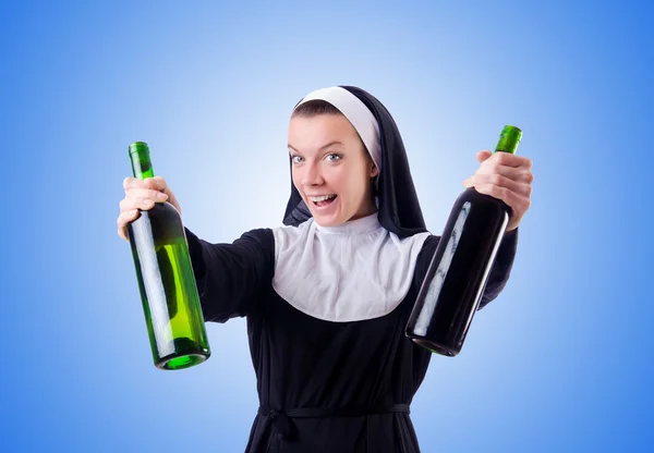 Nonne mit Flasche Rotwein — Stockfoto