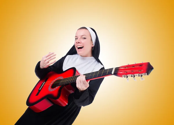 Monja tocando la guitarra contra el gradiente — Foto de Stock