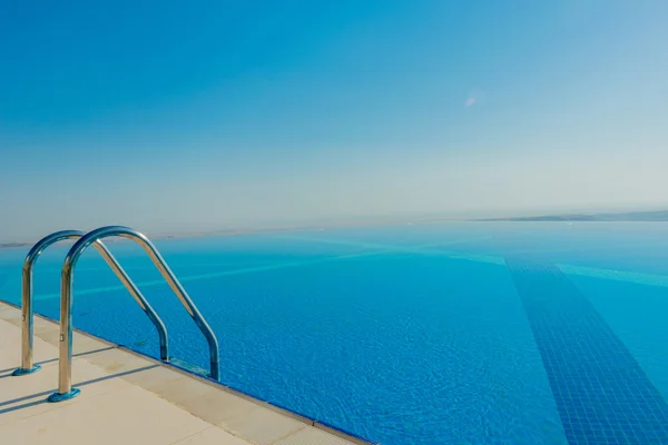 Piscina infinita no dia de verão brilhante — Fotografia de Stock