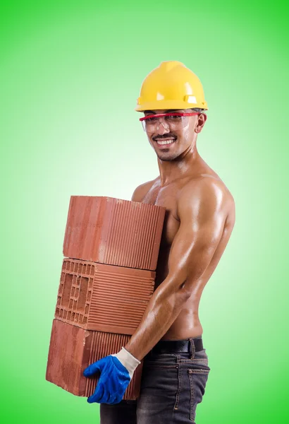 Construtor muscular com tijolos contra o gradiente — Fotografia de Stock