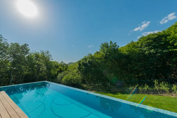 Piscina infinita en el brillante día de verano — Foto de Stock