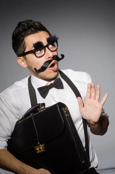 Young man with false moustache isolated on gray — Stock Photo, Image