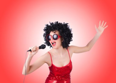 Degrade karşı Kırmızı elbiseli mikrofon ile pop yıldızı 