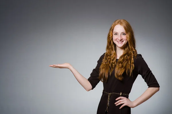 Hübsche rote Haare Mädchen in braunem Kleid gegen grau — Stockfoto