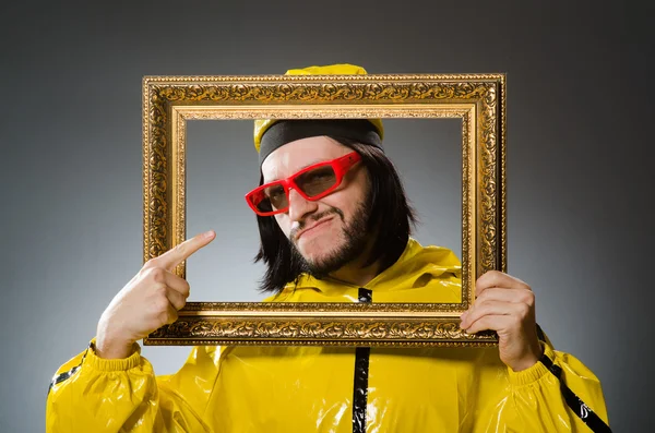 Man wearing yellow suit with picture frame — Stock Photo, Image