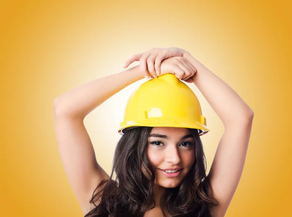 Young woman with hellow hard hat against gradient — Stock Photo, Image