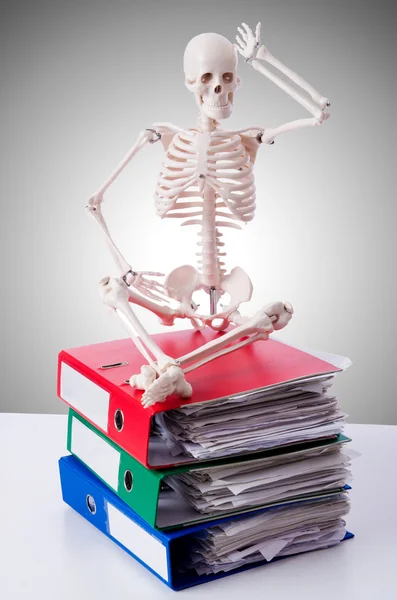 Skeleton with pile of files against gradient — Stock Photo, Image