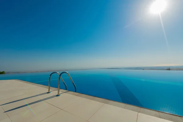 Piscina infinita en el brillante día de verano — Foto de Stock