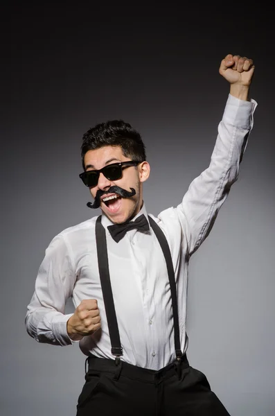 Jeune homme avec fausse moustache isolé sur gris — Photo