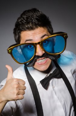 Genç adam sahte bıyık ve gri izole büyük güneş gözlüğü