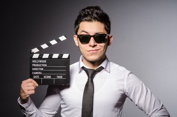 Young man in cool sunglasses holding chalkboard isolated on gray background