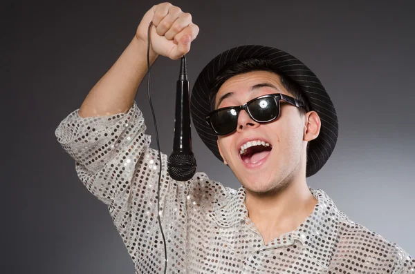 Молодой веселый певец с микрофоном — стоковое фото