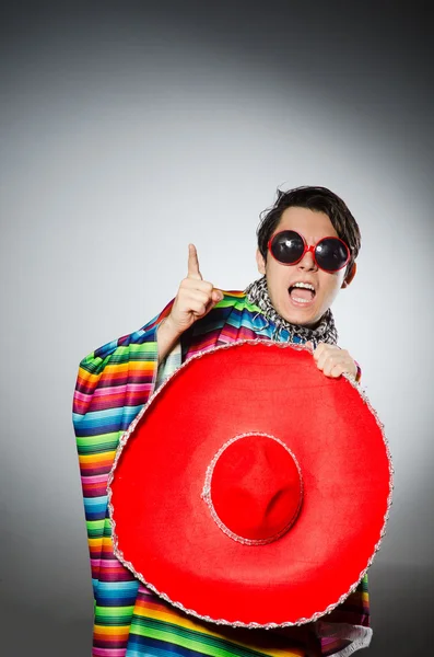 Hombre en poncho mexicano vívido contra fondo gris — Foto de Stock