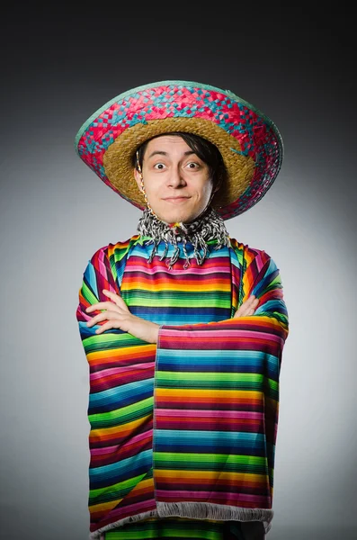 Hombre en poncho mexicano vívido contra fondo gris —  Fotos de Stock