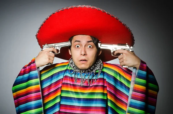 Man in levendige Mexicaanse poncho met handwapen tegen grijs — Stockfoto