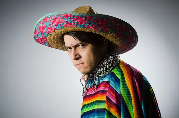 Hombre en poncho mexicano vívido contra gris — Foto de Stock