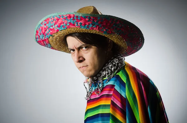 Homem em vívido poncho mexicano contra cinza — Fotografia de Stock