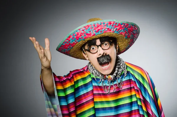 Hombre en poncho mexicano vívido contra gris — Foto de Stock