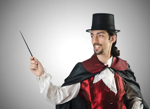 Magician doing tricks on grey — Stock Photo, Image