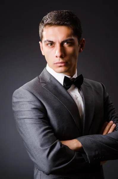 Joven hombre elegante contra gris — Foto de Stock