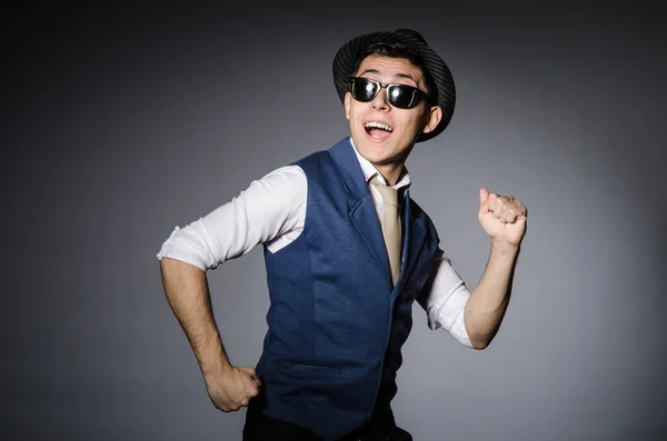 Young man in blue vest and hat against gray background — Stock Photo, Image