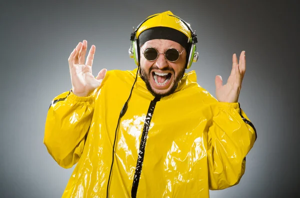 Człowiek nosi żółty komplet słuchania słuchawki — Zdjęcie stockowe