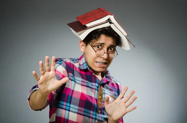 Estudante engraçado com muitos livros — Fotografia de Stock