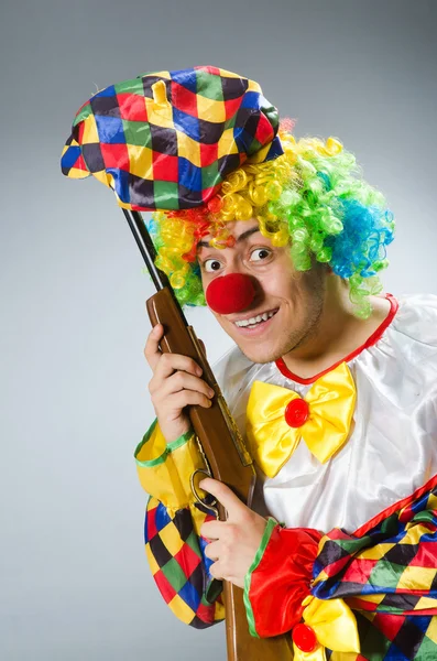 Clown med gevär mot lutningen — Stockfoto