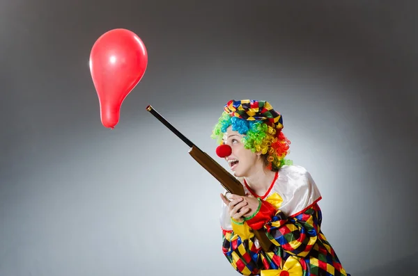 Clown mit Luftballon und Gewehr in lustigem Konzept — Stockfoto