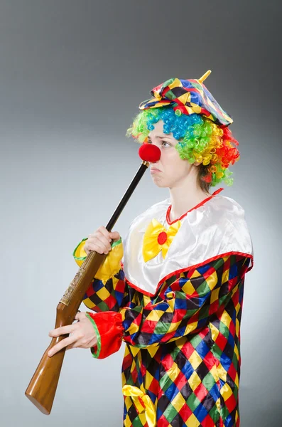 Clown met geweer tegen het verloop — Stockfoto