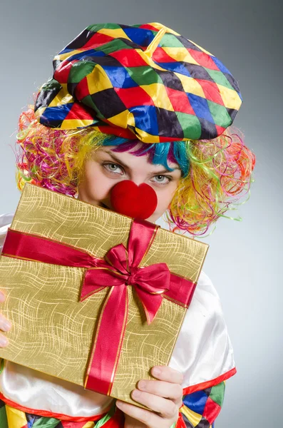 Клоун с подарочной коробкой в смешной концепции — стоковое фото