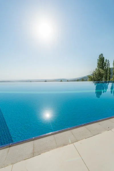 Piscina infinita en el brillante día de verano — Foto de Stock