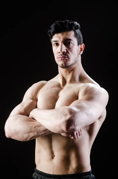 Hombre musculoso posando en estudio oscuro —  Fotos de Stock